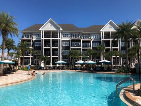 A spacious resort pool flanked by palm trees, offering a refreshing escape.