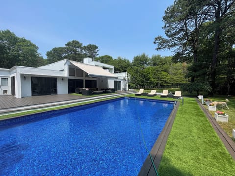 New heated swimming pool mahogany deck high end lounge chairs and awning