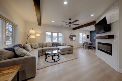 Beautiful wide open living room with TV and fireplace below. Windows galore! 