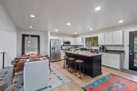 Fully stocked kitchen with breakfast bar seating for 3, dining area seating for 6