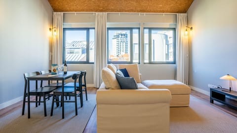 This bright and inviting living space is perfect for relaxing after a day of exploration, offering a comfortable sofa and a dining area where you can enjoy meals with a view of the city. #LivingRoom #CityView #ComfortLiving #DiningArea #ModernStyle #Brigh