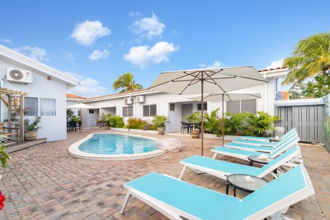 Amazing pool area of the apartment in Noord, Aruba - Cosy beach chairs and neat and clean towels available - Beautiful mountain view - Superbly designed pool area - Refreshing Environment - Vibrant Atmosphere - Great sitting under umbrella shades