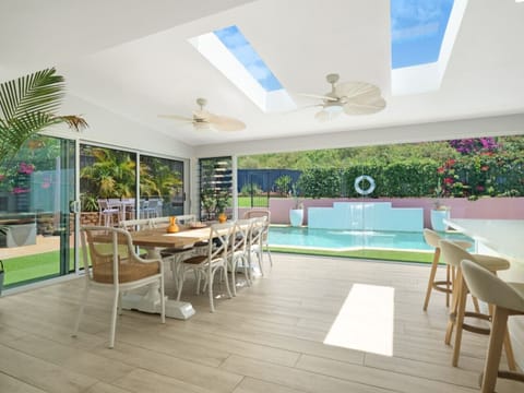 Floor to ceiling picture window frame the lush backyard and salt water pool