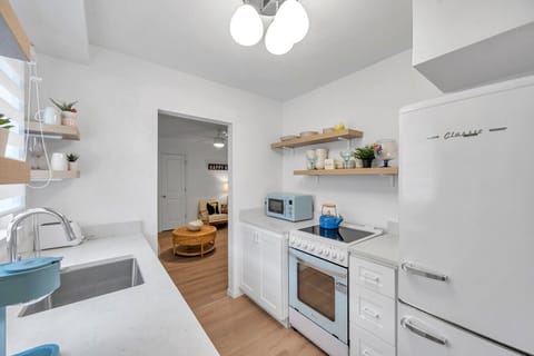 Functional kitchen layout w/ modern appliances, open shelves, and plenty of prep space.