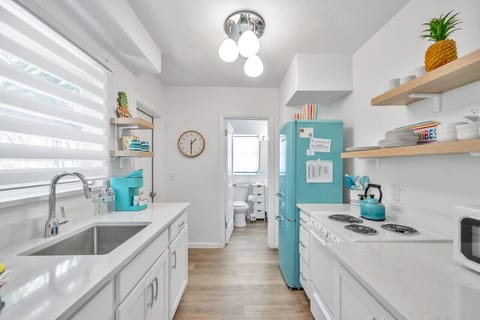 Light, functional kitchen w/ open shelving & a clean, welcoming layout.