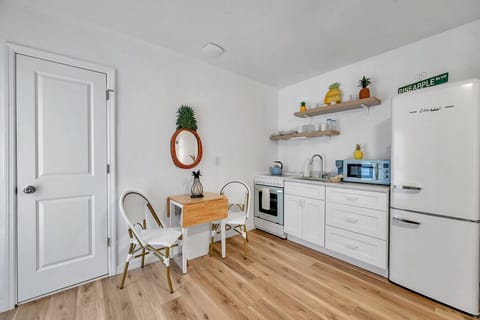 Clean, airy kitchenette w/ open shelving & a charming dining nook for relaxed meals