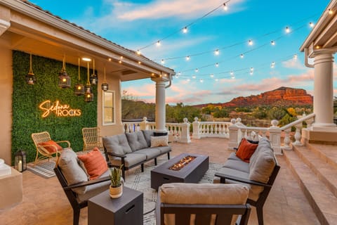 Stunning outdoor lounge with fire table, string lights, and panoramic Sedona red rock views - the perfect space for relaxing evenings at Villa of the Rocks.