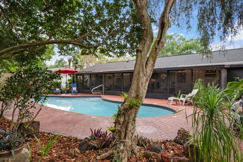 Huge inground pool surrounded by tropical landscaping and courtyards