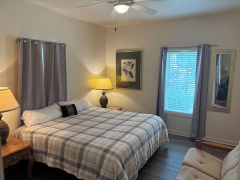 Spacious primary suite with a king bed, blackout curtains, comfortable sitting area and private en-suite bathroom.