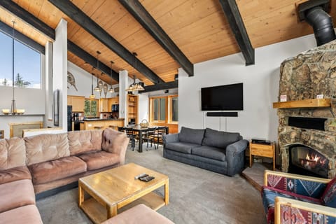 Spacious and inviting mountain retreat with vaulted ceilings, a warm stone fireplace, and an open living area perfect for relaxing and entertaining.