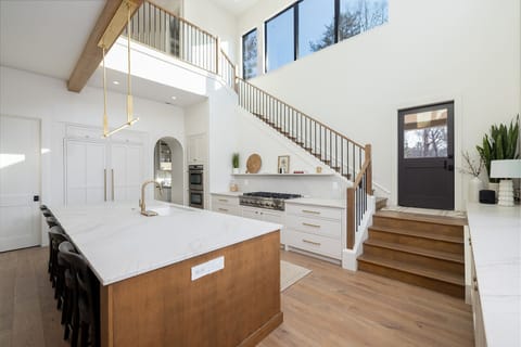 Staircase and kitchen with 23 ft ceilings.