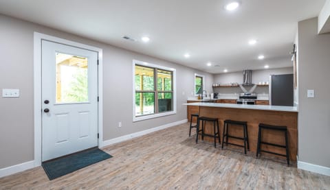 Island location in reference to the door leading out on to the concrete patio across from the firepit.