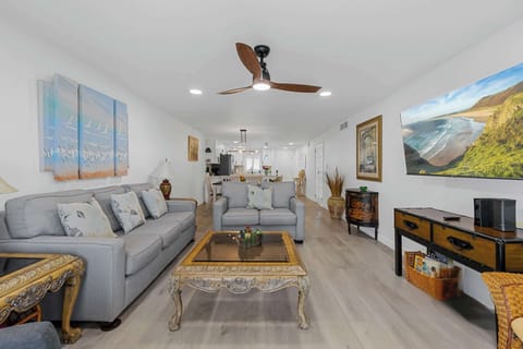 Spacious living room with comfortable seating and coastal artwork for a relaxing stay.