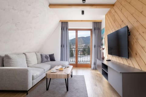 Living room with a view of the mountains, a sofa bed and TV.