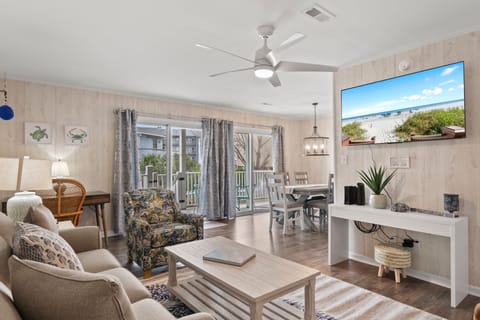 Relax in your bright, coastal-inspired living space with comfortable seating, modern entertainment center, and dining area perfect for memorable meals together.