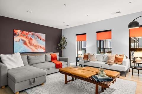 Chic living room with comfy sectional, love seat, floor cushions, and smart TV 