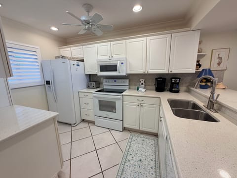 Step into your fully equipped kitchen with modern appliances, bright white cabinetry, and plenty of counter space for preparing meals together—your home away from home awaits.