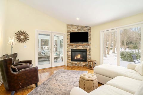 Living room with a Smart TV, seasonal gas fireplace, and access to the sunroom and patio