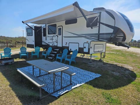 An exterior view of the RV, showcasing a cozy seating area designed for friends and family to relax and enjoy together