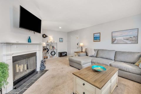 Living room with gray sofa, fireplace, and wall-mounted TV