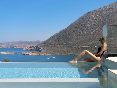 Bask in the sun by the elegant pool, surrounded by stunning views & comfort