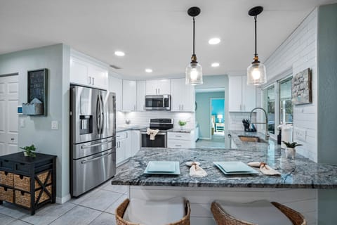 Enjoy a fresh, airy kitchen with ample counter space, modern lighting, and everything you need for a home-cooked meal.