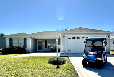 House Front View with Electric 2-Seater Golf Cart for Guest Use
