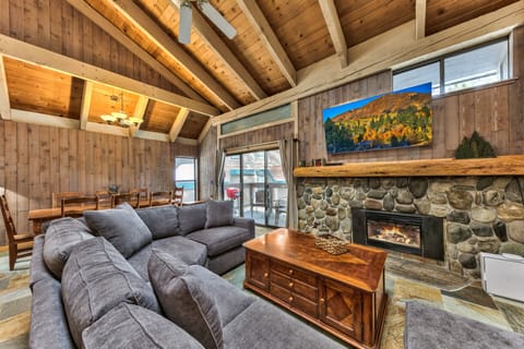 Curl up on the plush sectional by the fireplace, where vaulted wood ceilings create perfect warmth for cozy evenings.