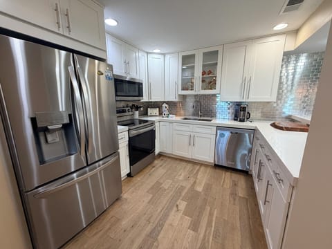 Cook your favorite meals in this bright, modern kitchen with stainless appliances, sleek tile backsplash, and plenty of counter space for all your culinary adventures.