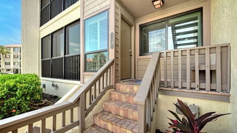 The property entrance features a covered porch with easy access steps and natural surroundings, situated in a quiet residential neighborhood.