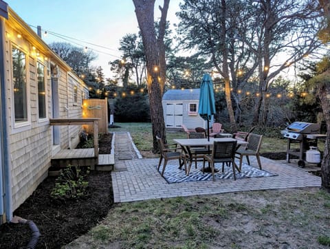 Outdoor patio with bistro lights and a Weber grill