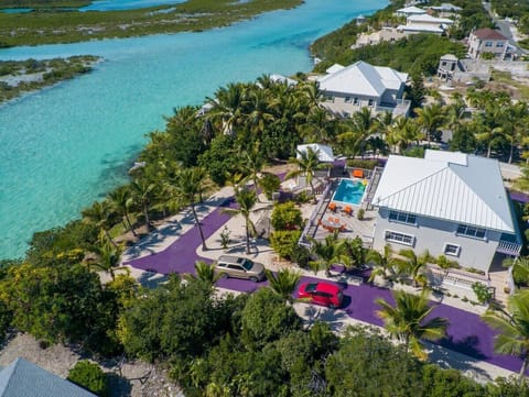 Enjoy stunning views of the villa nestled between lush trees and turquoise waters