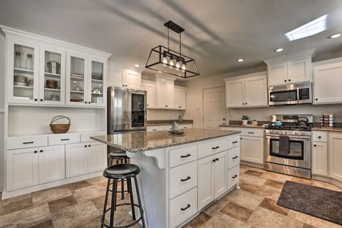 Fully equipped kitchen with appliances, counter space, and breakfast bar seating.