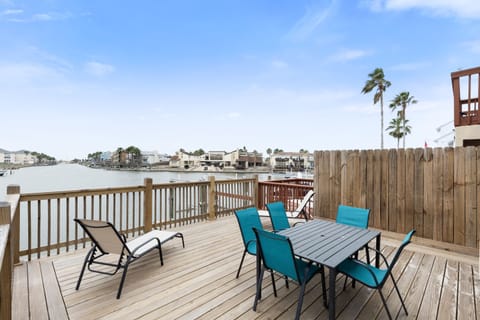 Savor waterfront dining on your private deck with turquoise chairs and stunning canal views.