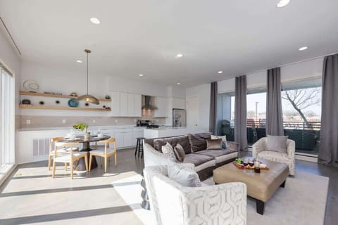 Bright open floor living space featuring designer furnishings, a smart TV, a fireplace, and access to a private balcony. (2nd Floor)