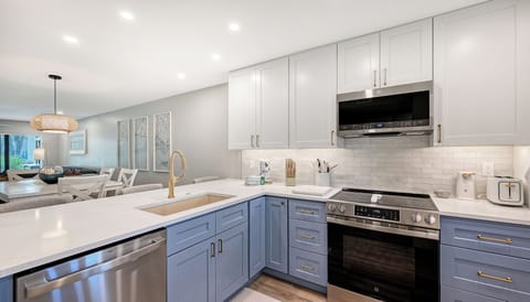Your gourmet kitchen features sleek two-tone cabinetry, gleaming quartz countertops, and top-of-the-line stainless steel appliances—perfectly designed for preparing your favorite meals in style.