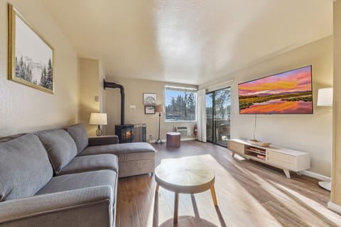 Cozy up in your stylish living space with modern furnishings, fireplace warmth, and large windows framing beautiful outdoor views.