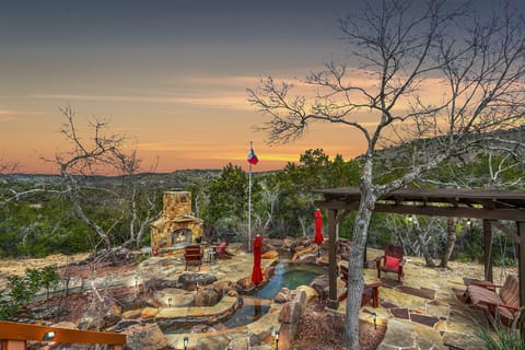 Backyard oasis with waterfall pool, covered seating, and outdoor fire place!
