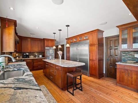 Warm kitchen w/ island seating, wood cabinetry & generous counter space for cooking together.