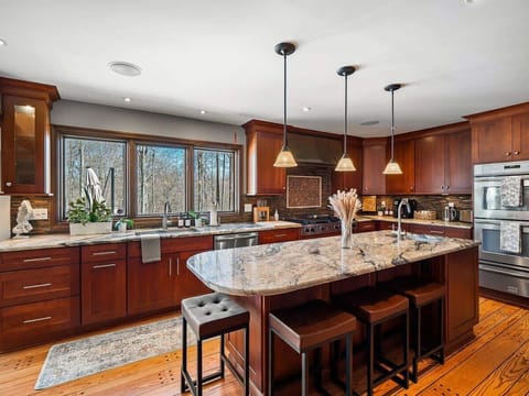Spacious kitchen w/ large island, bar seating & rich wood cabinetry for easy meals together.