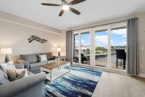 Living Area with Sleeper Sofa, Dining Table, Balcony Access & Lake Views