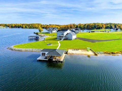 A picturesque lakefront property featuring a private boathouse, sandy beach, and spacious lawn, perfect for a serene vacation