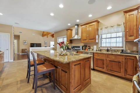 The kitchen features two ovens, and stainless steel hood.