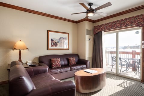 - Bright living room with leather seating and mountain view balcony  
- Sliding glass doors bring in natural light and fresh alpine air  
- Relax after a day on the slopes in your comfortable mountain retreat