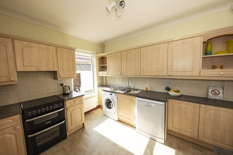 The kitchen with washer, dishwasher, electric oven, grill, hob, microwave
