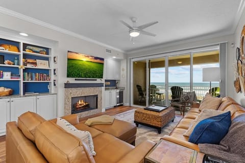 Beautiful decor living area with fire place, wine refrigator, shelving, TV