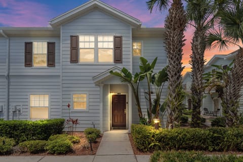 Step into a charming exterior framed by lush palm trees and vibrant greenery, inviting you to explore what's inside. The soft glow from the windows hints at a cozy atmosphere, perfect for unwinding after a day of adventure.