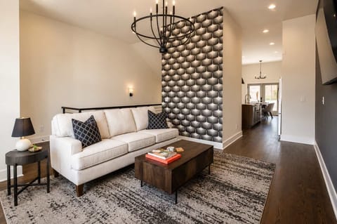 White sofa and floor-to-ceiling window create a welcoming, sunlit space.