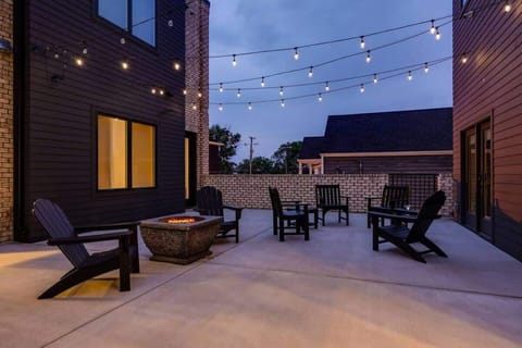 Bistro-lit patio with lounge, dining, fire pit & BBQ for guests.