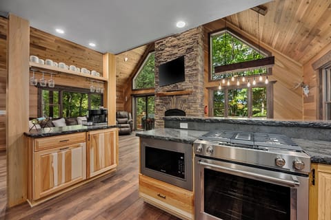 Gorgeous chef's Kitchen with gas oven/stove, stone counters and coffee station looking into the Great Room.